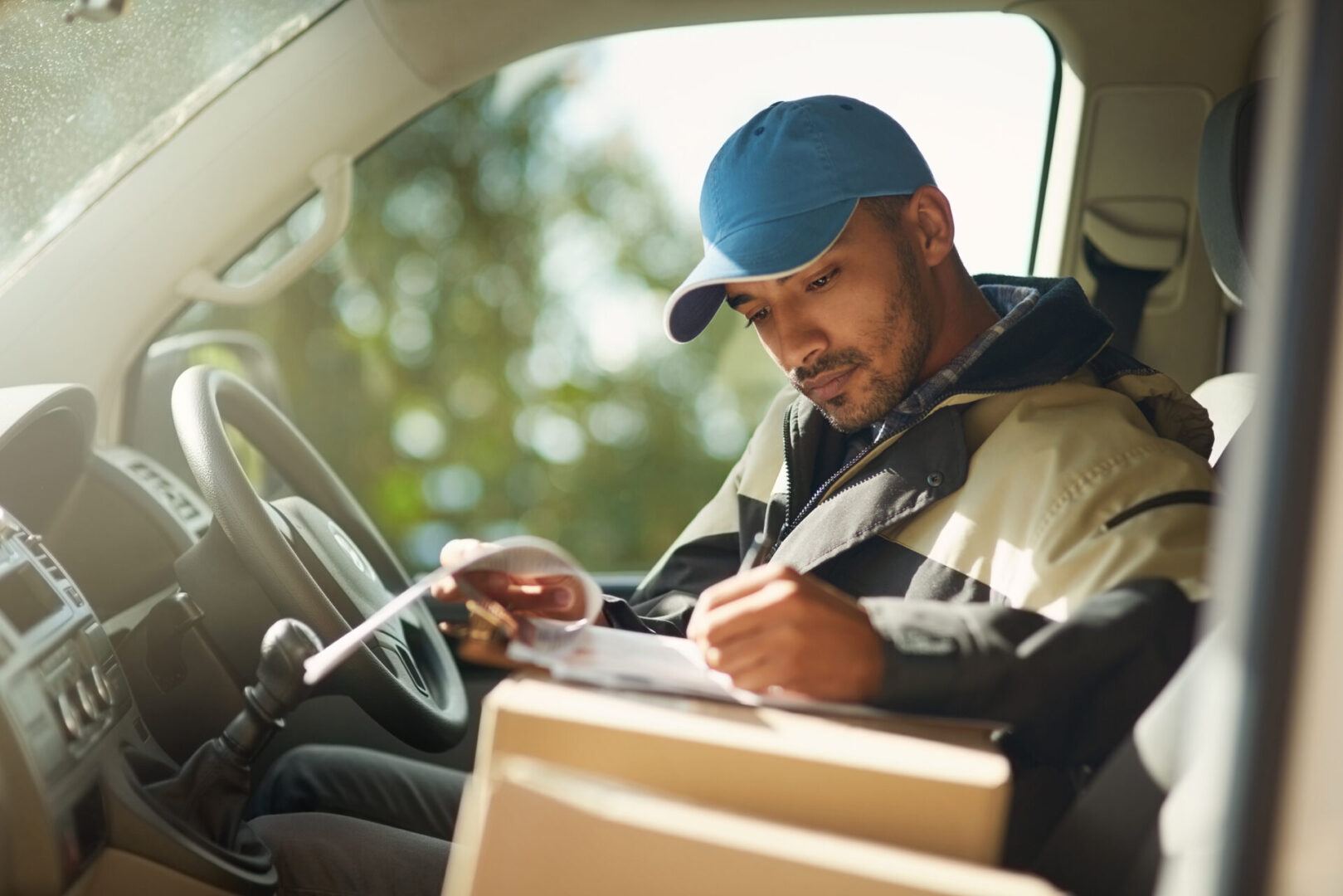 Delivery driver checking documents in vehicle.