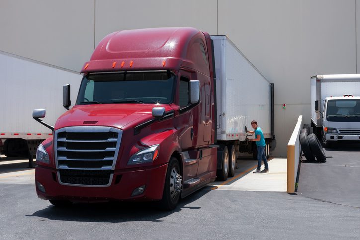 Red semi truck at warehouse loading dock